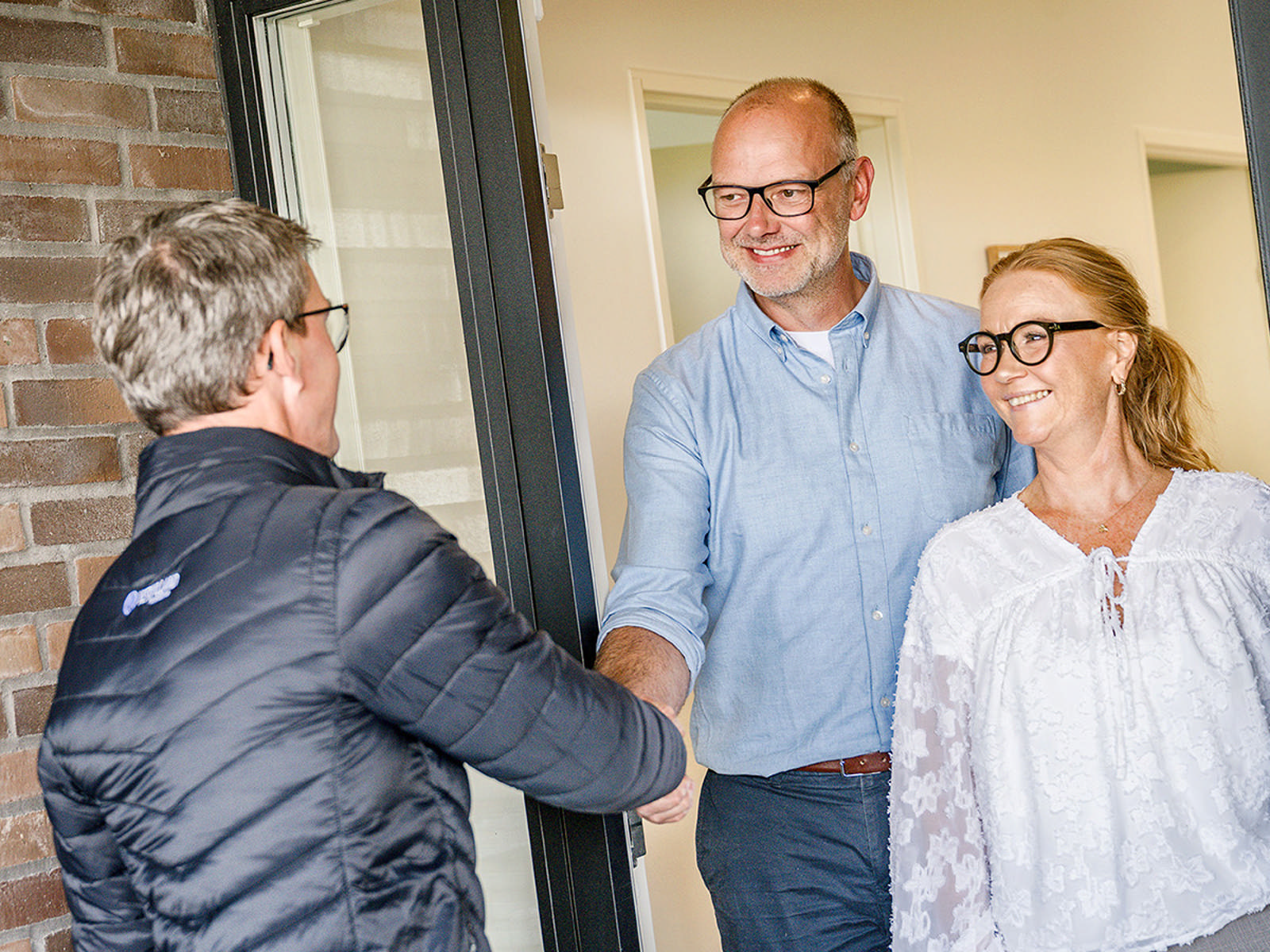Assurandør ved spisebord sammen med yngre par